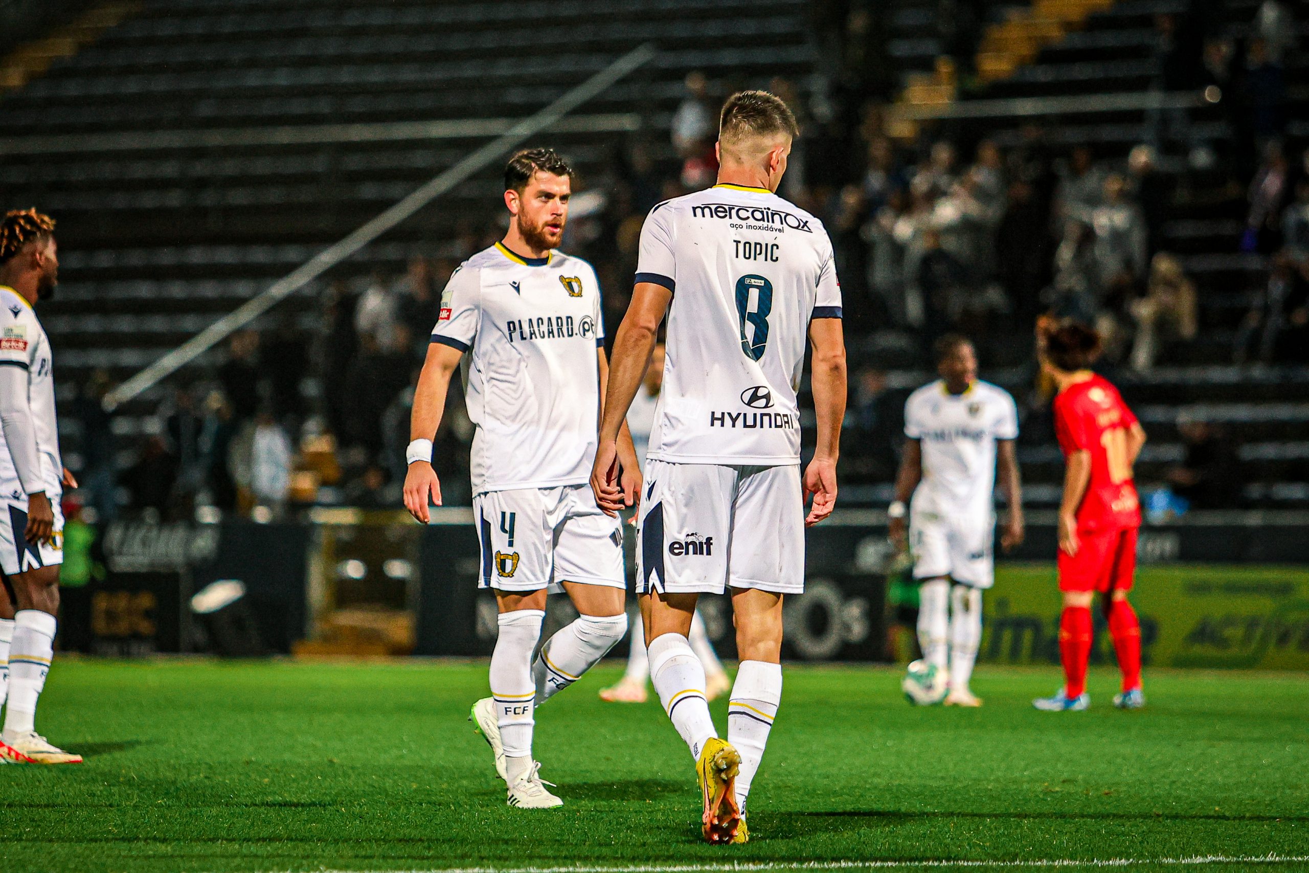 Um jogo de futebol com três jogadores em campo